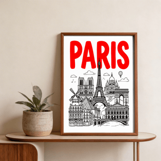 Framed Paris City Art Print with red text and black line-art landmarks on a table with a plant