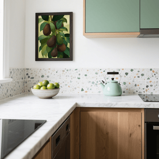 Avocado wall art with hanging avocados and green leaves in a kitchen above a bowl of limes