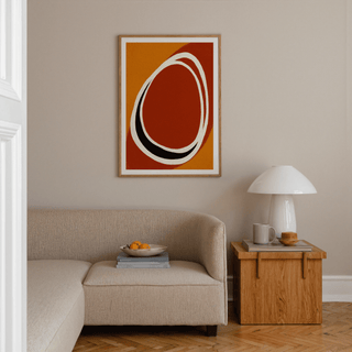 Modern Minimalist Art Print with abstract shapes in orange and rust above a beige sofa and wooden side table