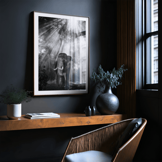 Nature Photography wall art of an elephant in a forest with sun rays framed on a dark grey wall above a wooden shelf with plants