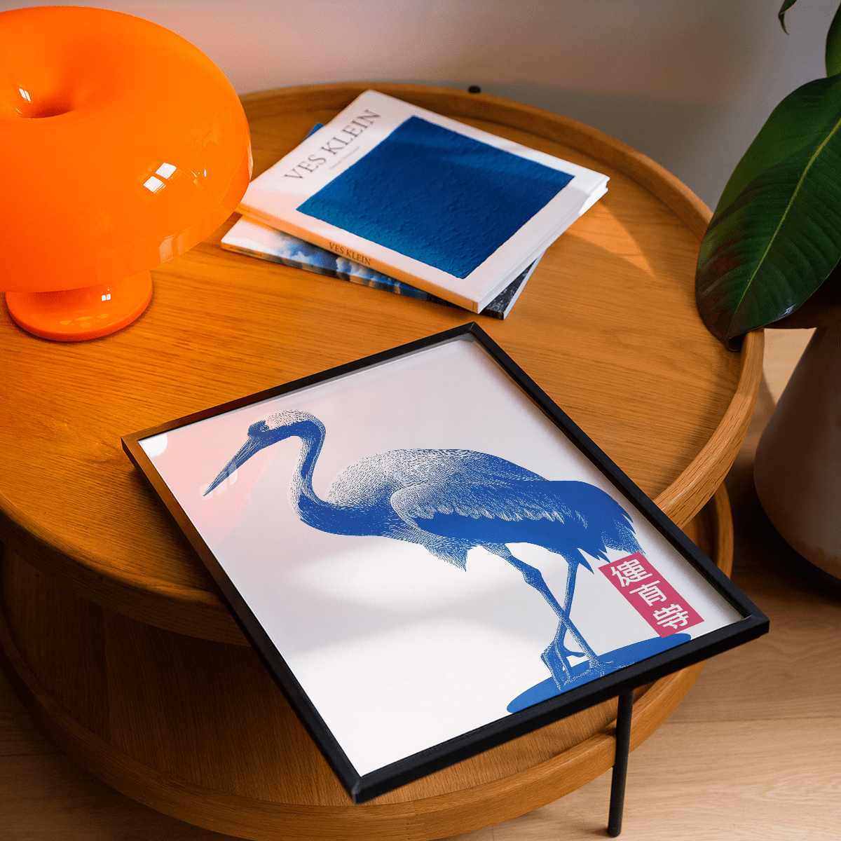 Framed Crane Wall Art illustration of a blue crane in minimalist japanese-ink style on a wooden table
