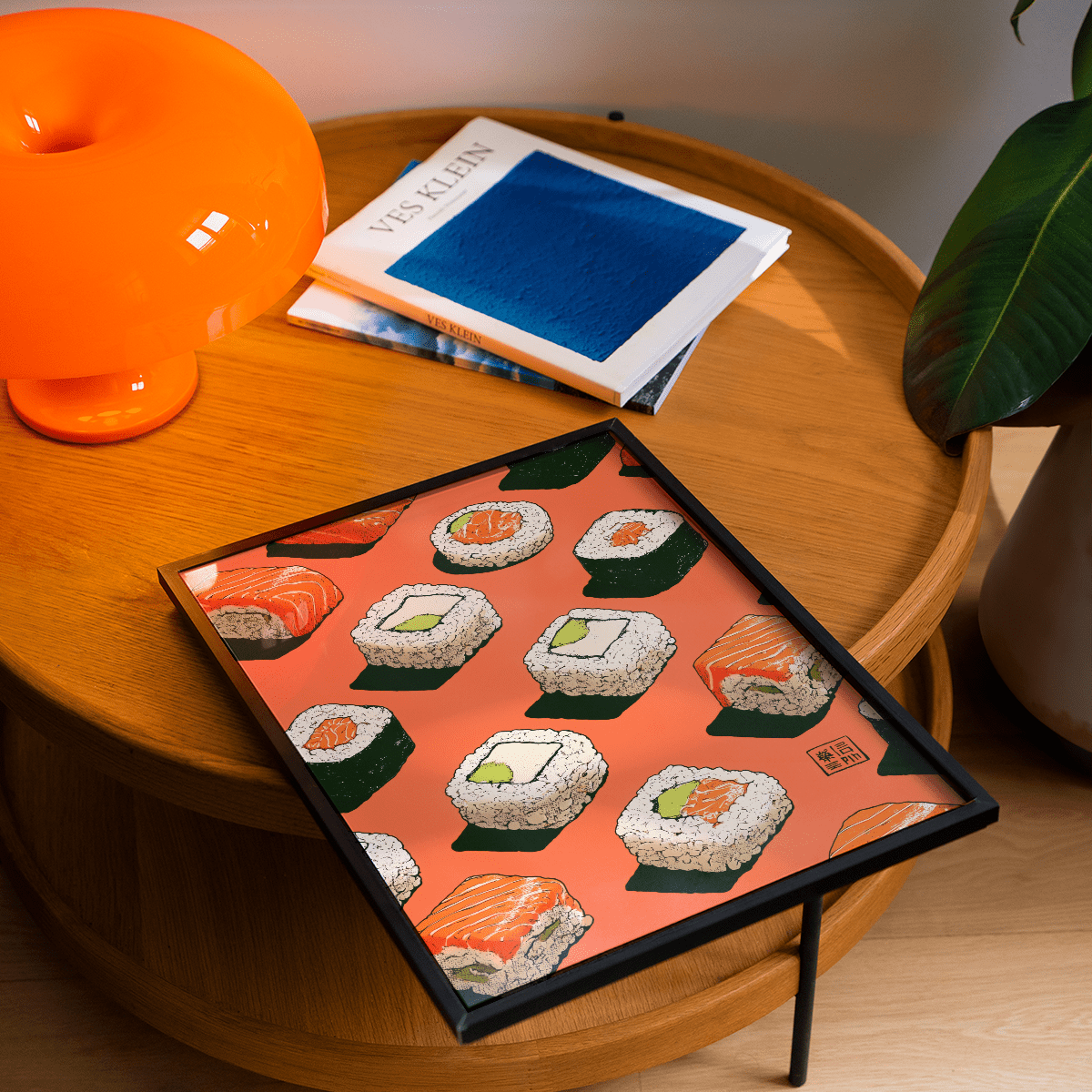 Framed Sushi Wall poster leaning on a wooden table with sushi illustrations on orange background