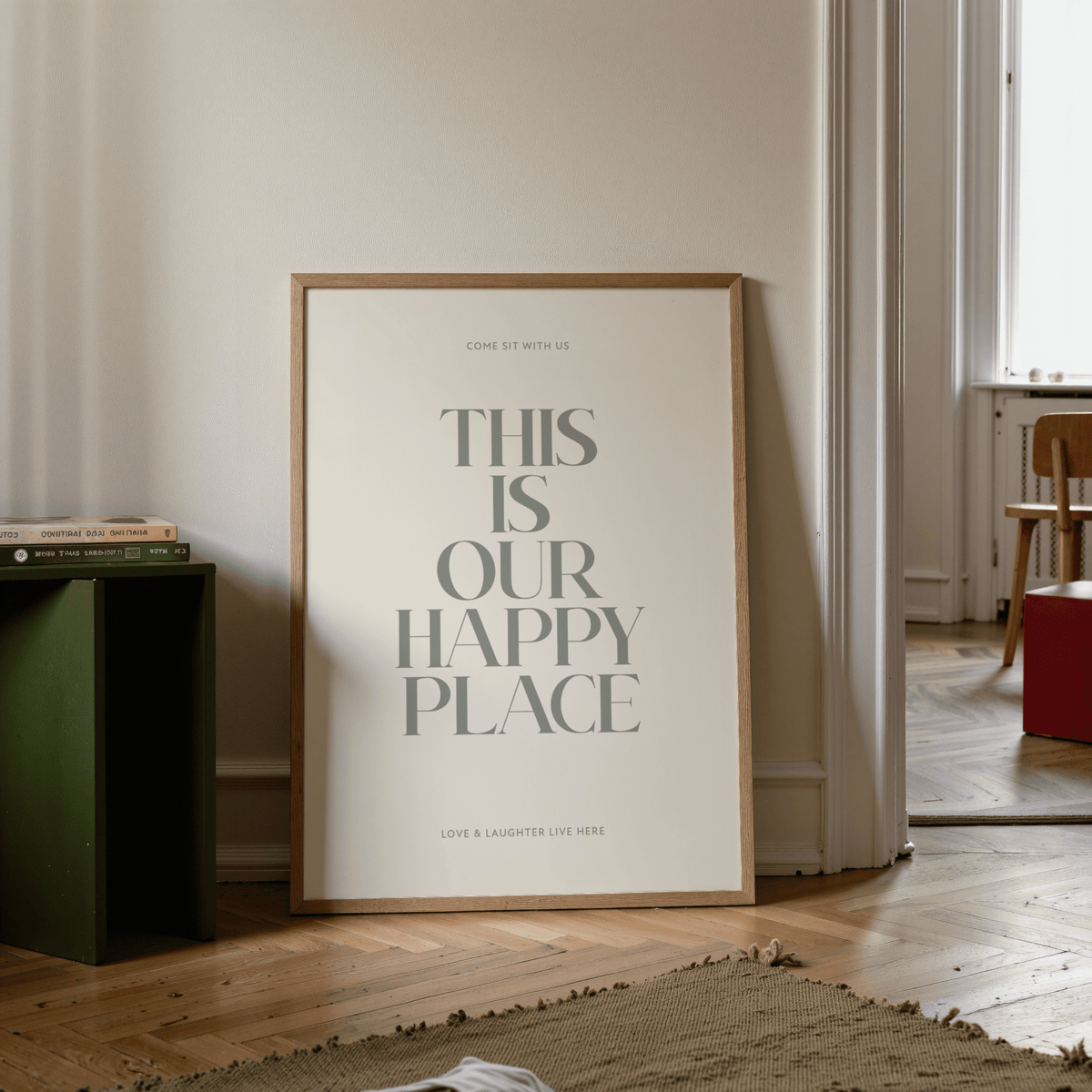 Inspirational Wall Sign print leaning on wooden floor with green side table and books nearby