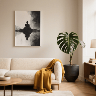 Meditation Art Print framed print of a meditating Buddha statue in black and white above a cream sofa with a yellow throw