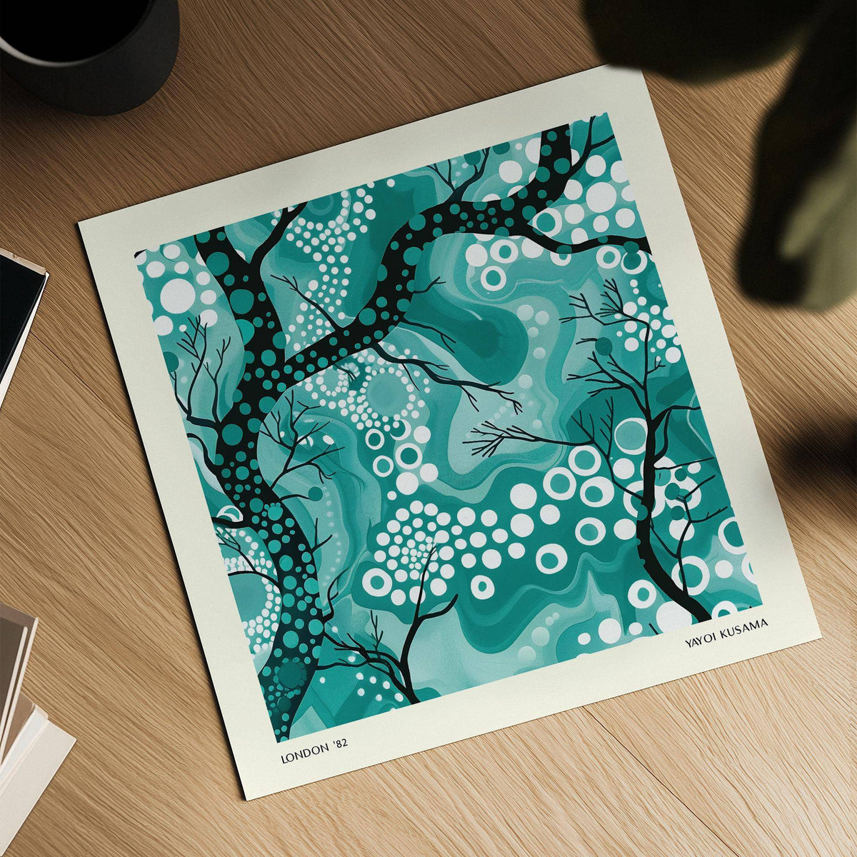 Print showing teal abstract wall art with black branches and white dots on a wooden surface