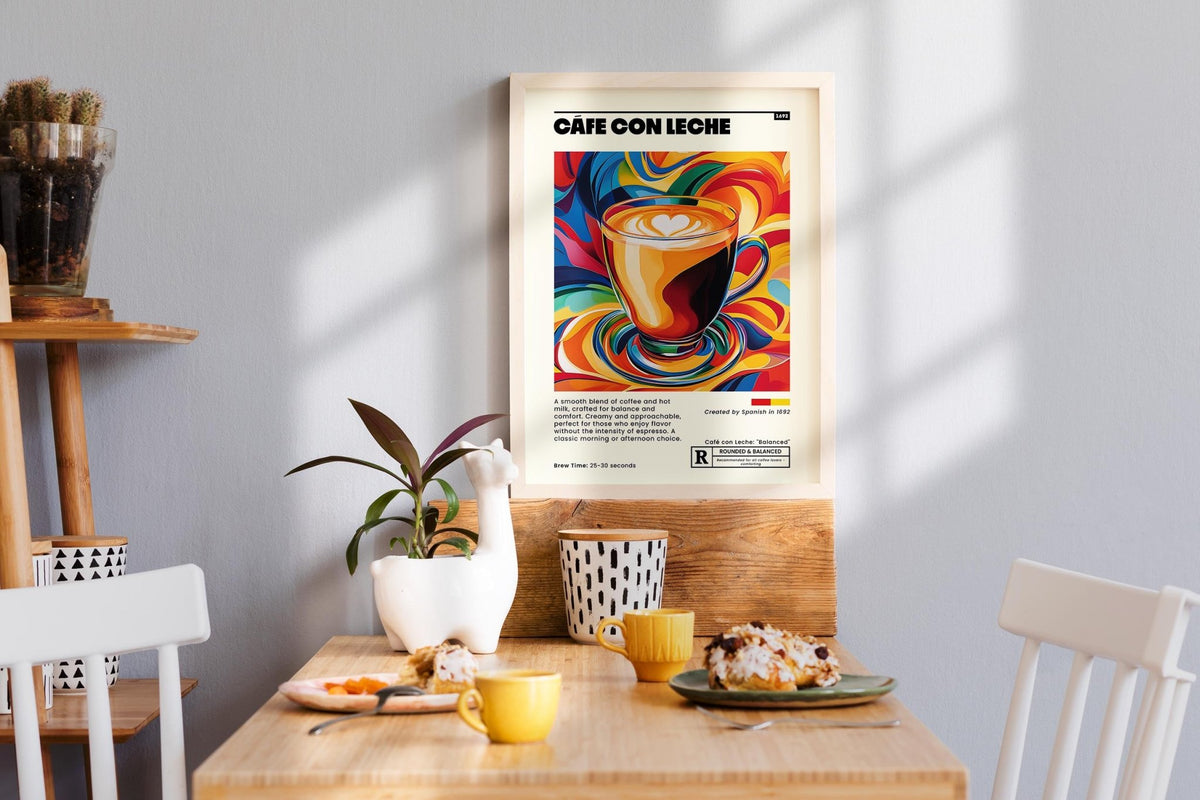 Cafe Con Leche Art print on a kitchen wall above a wooden table with cups and a pastry