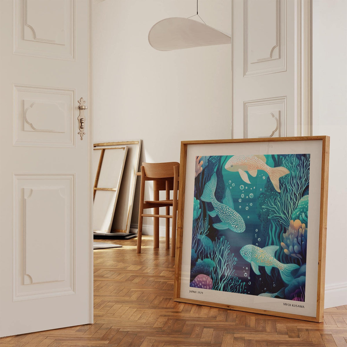 Print leaning on a wooden floor of contemporary spotted fish in blue and teal tones