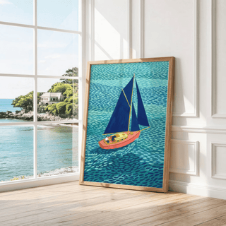 Colorful Sailboart Poster leaning on a wooden floor with large windows showing a coastal view
