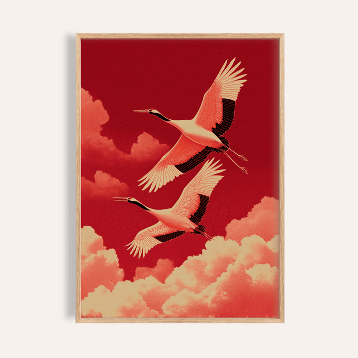 Framed Flying Cranes wall art of two red crowned cranes flying above orange clouds on dark red background