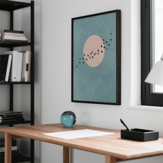 Wall Art Birds print with black birds on blue and pink background above a desk with glass paperweight