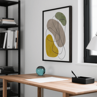 Geometric Abstract Poster framed print of organic shapes in green mustard and grey on a white wall above a wooden desk with a glass