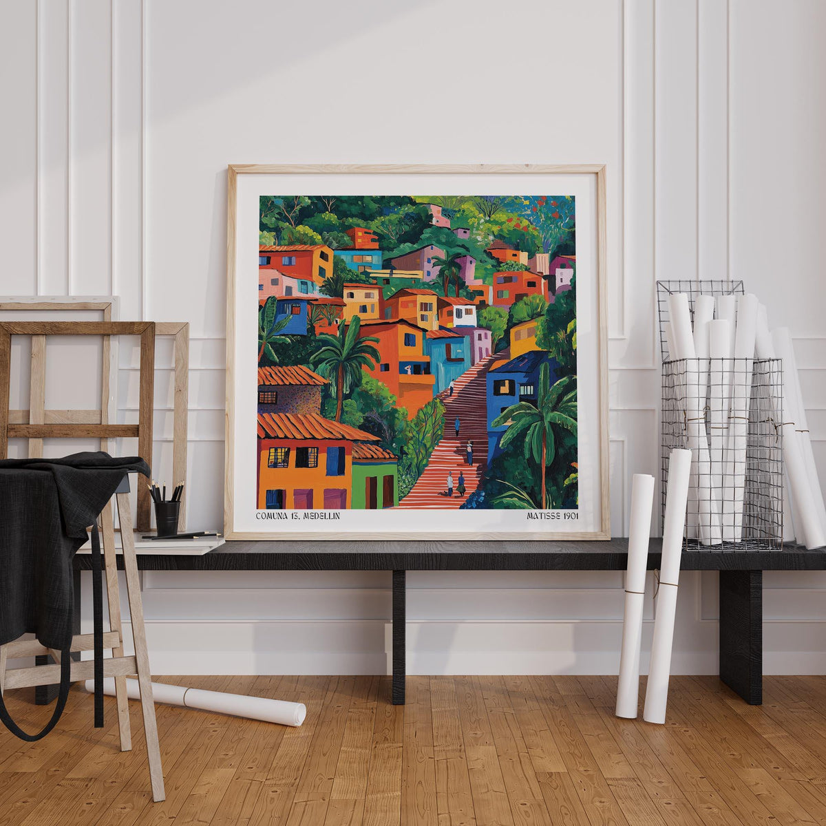 Comuna 13 Art print leaning on a black table with wooden floor and white wall panels