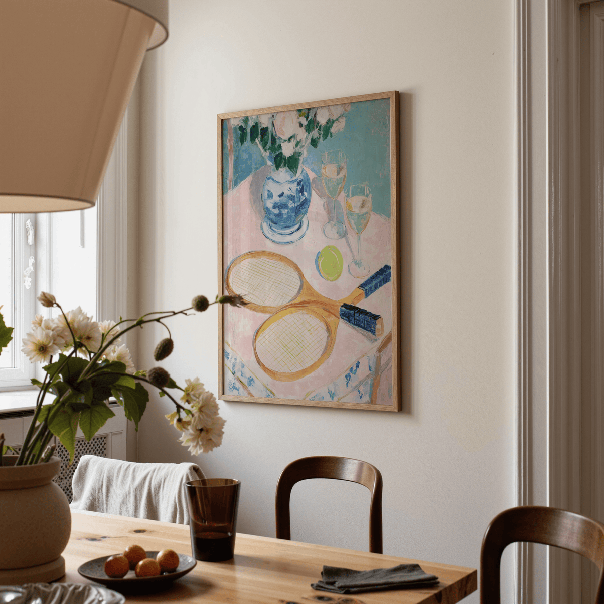 Tennis Still Life Print showing wooden tennis rackets and ball in soft colours on a dining room wall