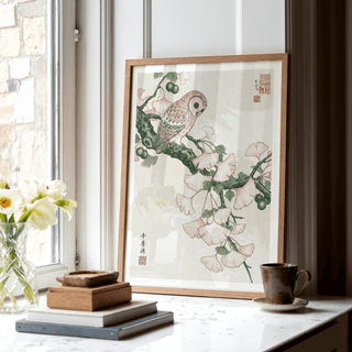 Owl Art Print leaning on a window sill with a cup and stacked books nearby
