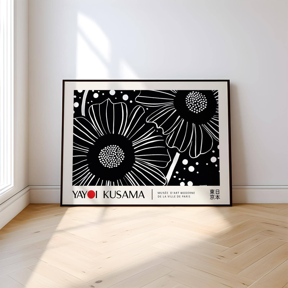 Horizontal wall hanging with black and white floral line-art leaning on a wooden floor near a window