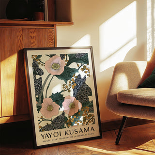 Pink wall art for bedroom leaning on a wooden floor showing pink flowers and green leaves near a chair