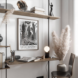 New York Cityscape wall art in black white and grey above a desk with books and a lamp