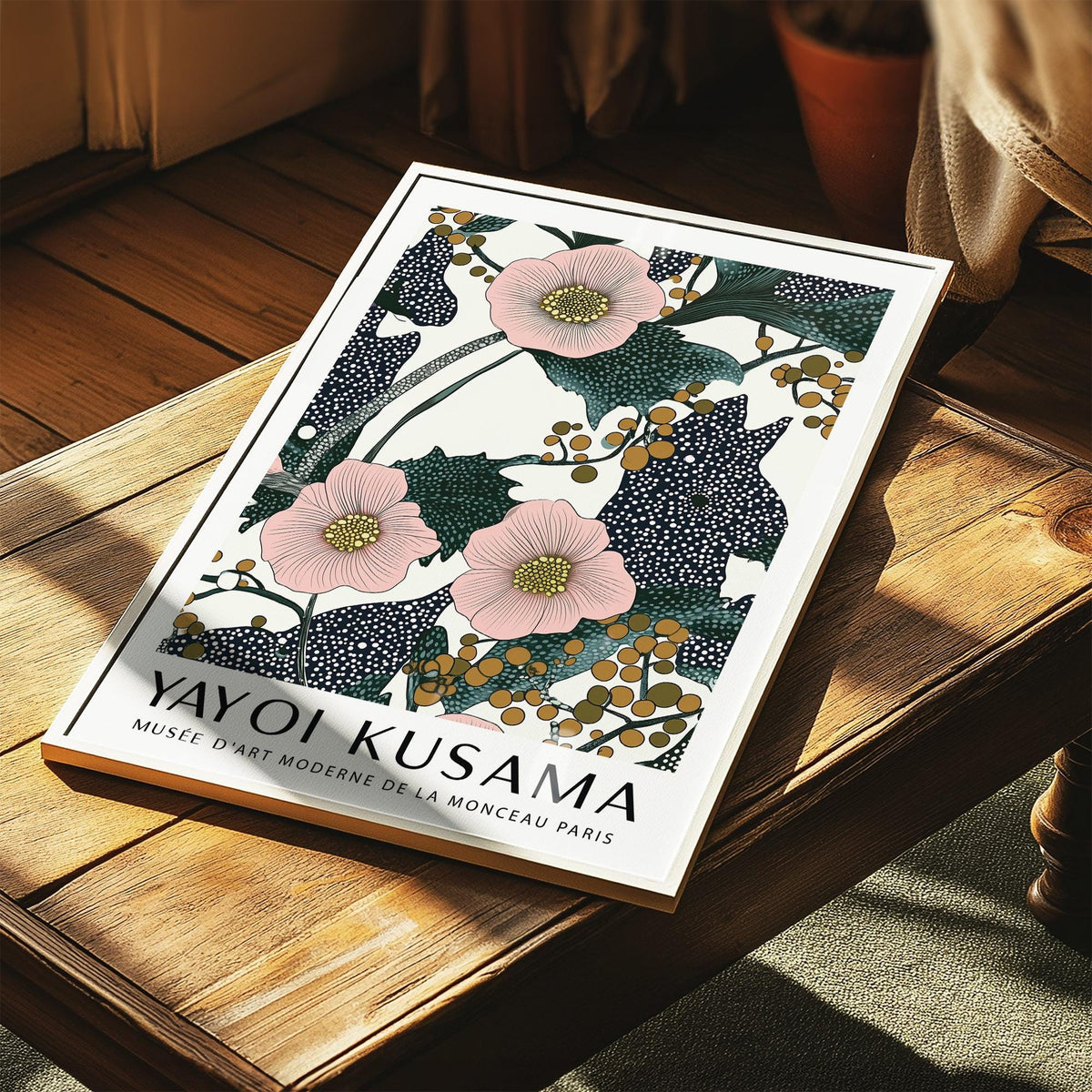 Pink wall art for bedroom with pink flowers and berries print leaning on a wooden table