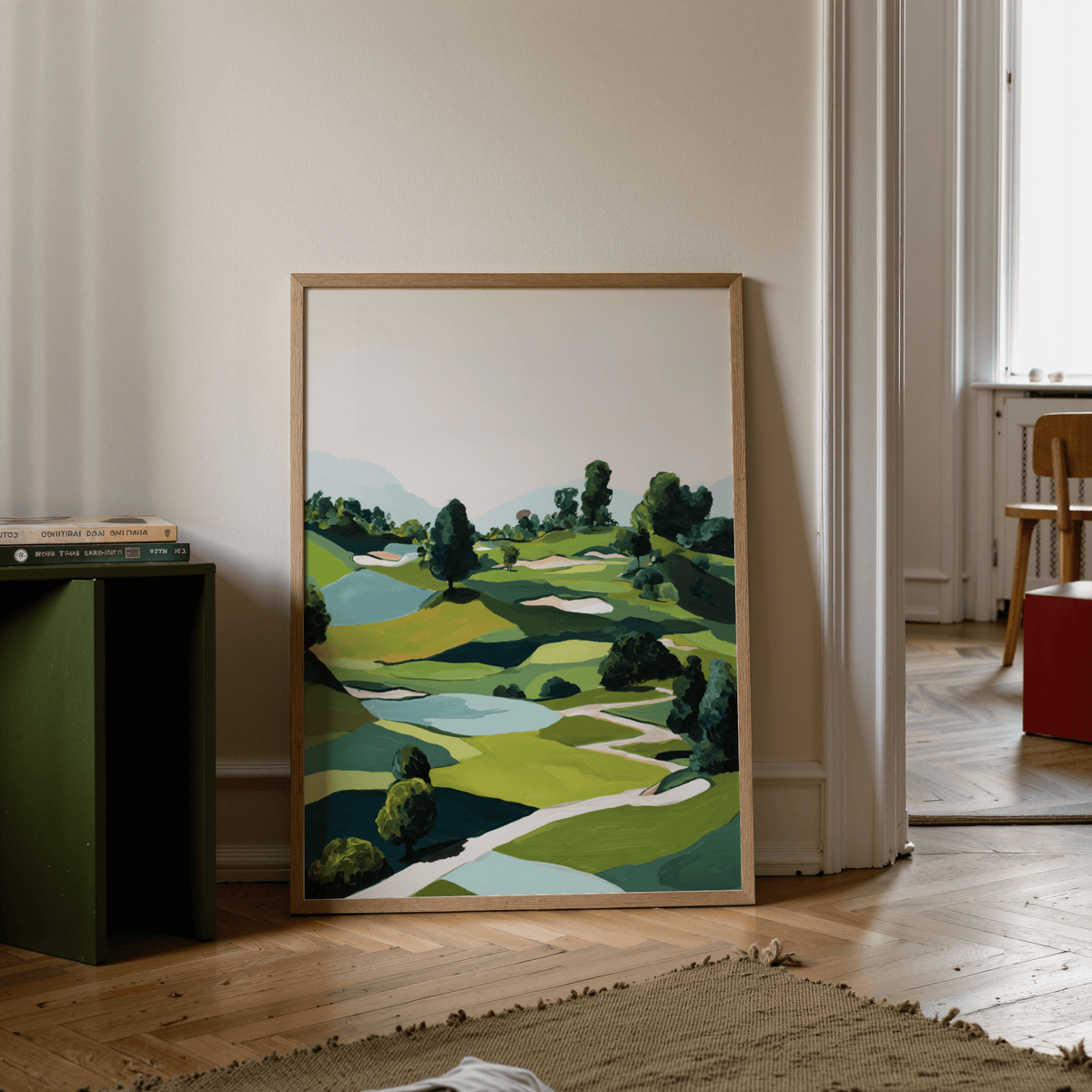 Landscape Golfing Poster print leaning on the floor with a green side table and books nearby in a neutral room