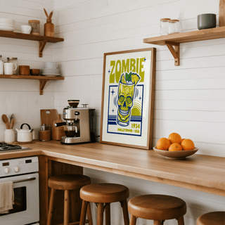 Zombie Cocktail Art Print leaning on a kitchen counter beside a coffee machine and bowl of oranges