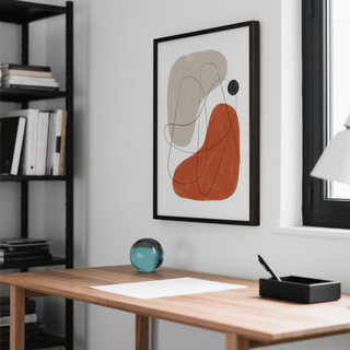 Simple Abstract Art framed print with beige and orange shapes above desk with teal glass orb