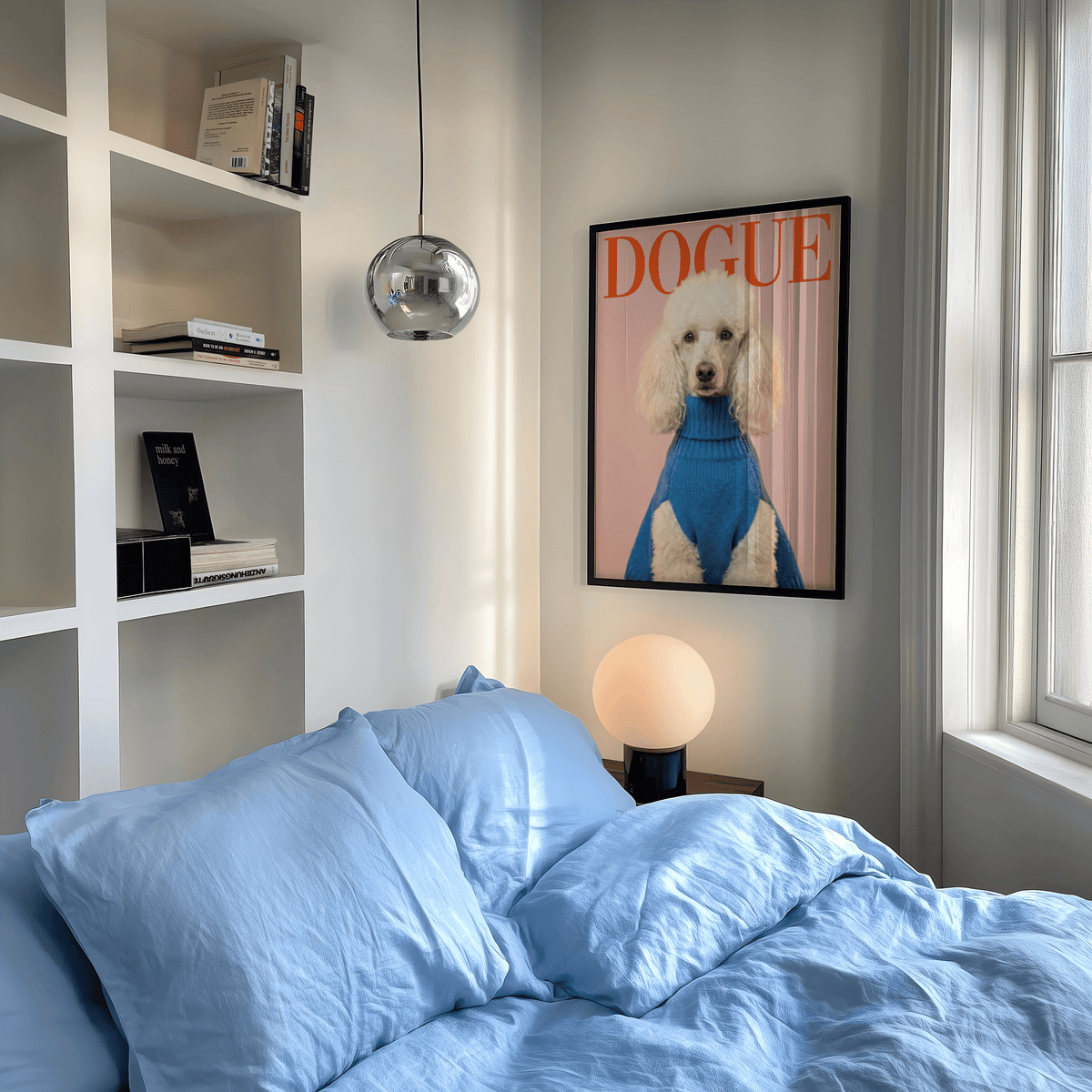 Dogue Poodle Print on a bedroom wall above a bedside lamp with blue bedding