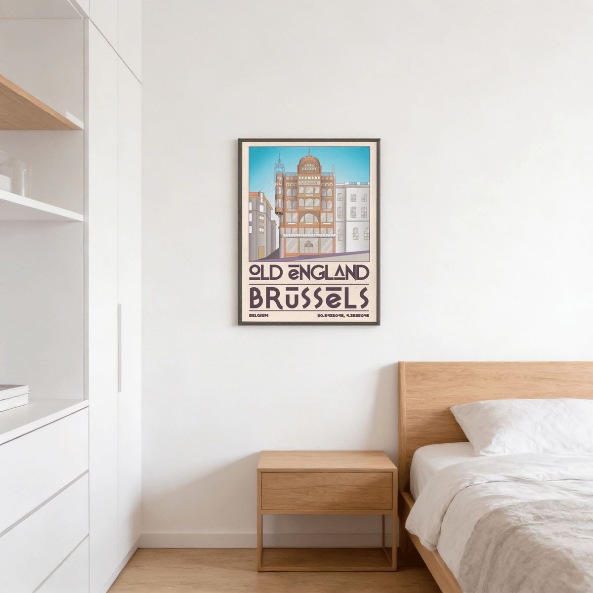 Framed Brussels Architecture Print of an Old England building with blue sky above a bedside table in a bedroom