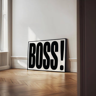 Print leaning on floor of office wall art BOSS typography in black on white with black frame