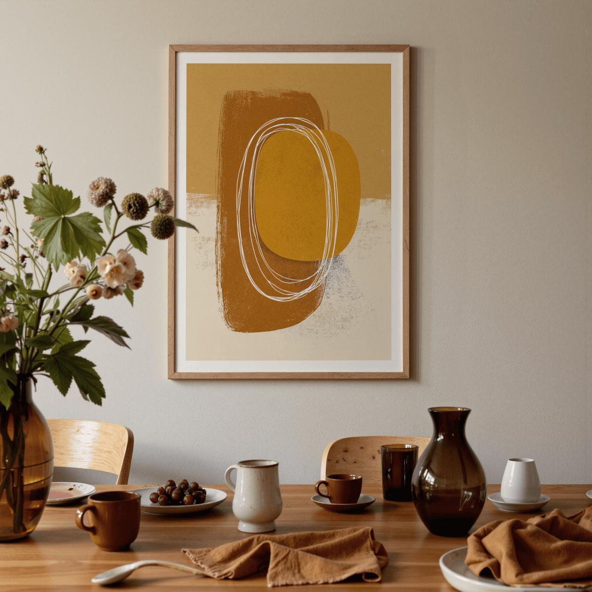 Minimalist organic wall art with abstract brown and mustard shapes above a dining table with assorted cups and a flower vase