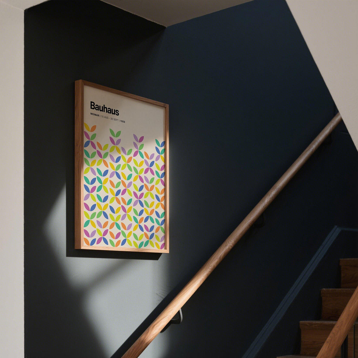 Colorful Bauhaus Poster framed print with abstract colorful petals on a dark wall above a staircase