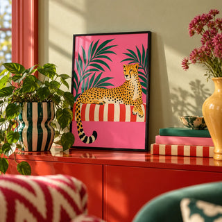 Cheetah Siesta Poster, a small A4 framed print leaning on a colourful lacquered shelf in a living room