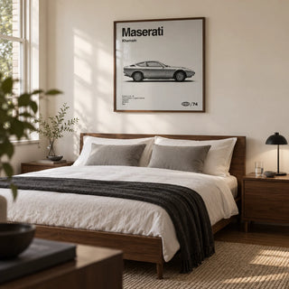 Classic 1970s Grand Tourer Poster, framed on the wall of a restrained bedroom for a classic-car enthusiast in a UK home with a warm white wall and walnut bedside furniture