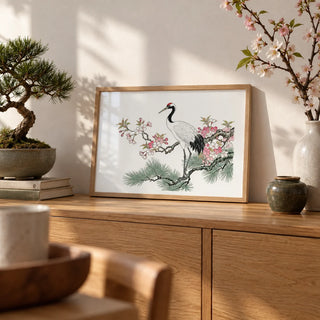 Crane Cherry Blossom Art Print, a small A4 framed print leaning on an oak sideboard in a living room