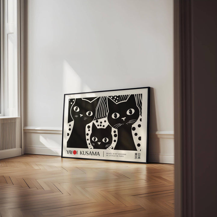 Black Cat wall art leaning on wooden floor with natural light in a white room