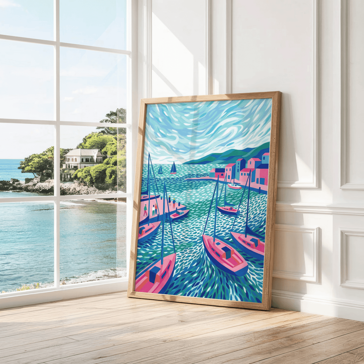 Print leaning on a floor by a bright window showing blue and pink sailboats in a harbour with swirling water