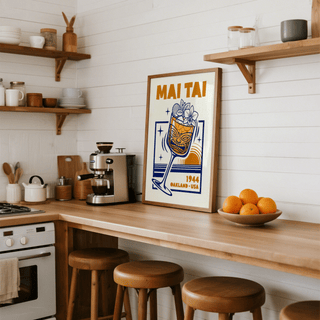 Print leaning on a kitchen counter of Mai Tai wall art with golden and navy illustration and text
