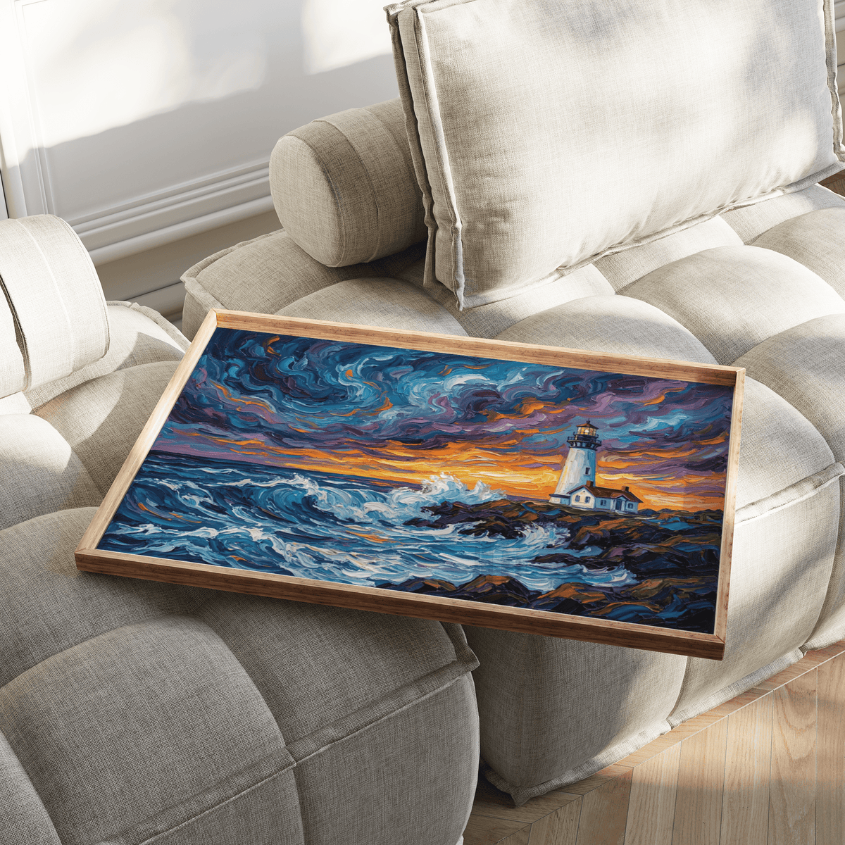 Ocean Landscape Print with lighthouse on rocky coast in vibrant blues and oranges on a beige sofa
