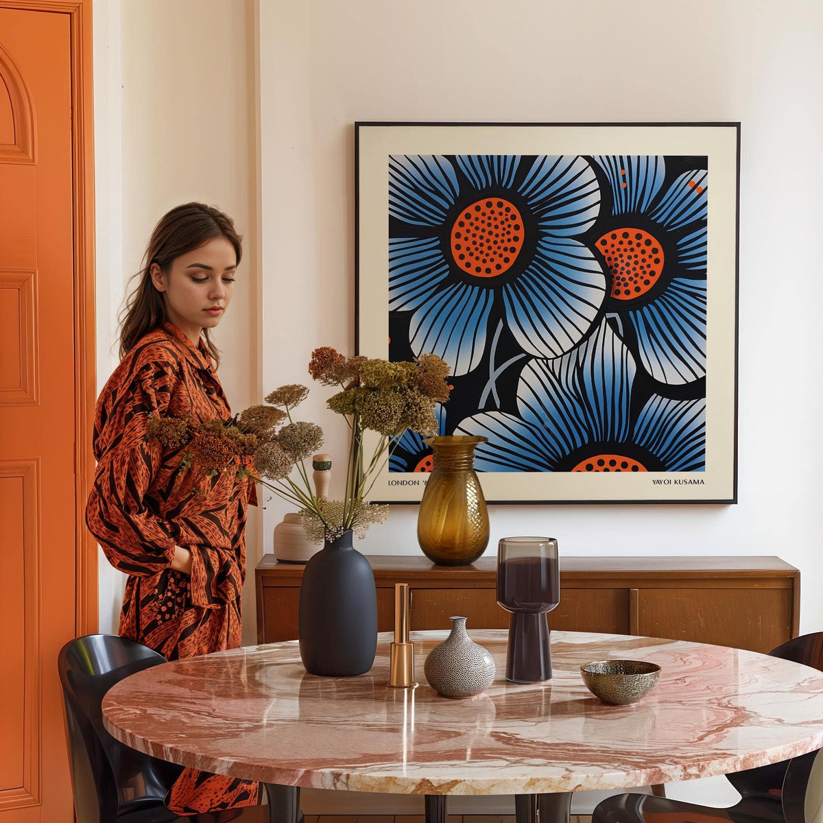 Blue flower wall art with orange and blue pop-art style flowers above a wooden sideboard in a dining room