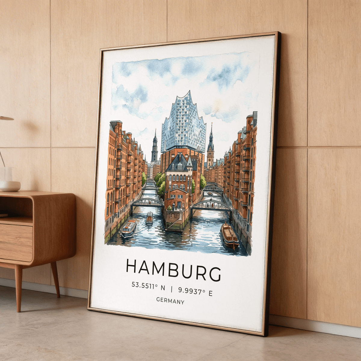 Framed Hamburg Cityscape Art Print showing a watercolor of Speicherstadt canal leaning against a wood wall with a table beside it