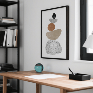 Modern Pebble Print framed print with beige orange and black pebbles above a wooden desk with a glass sphere