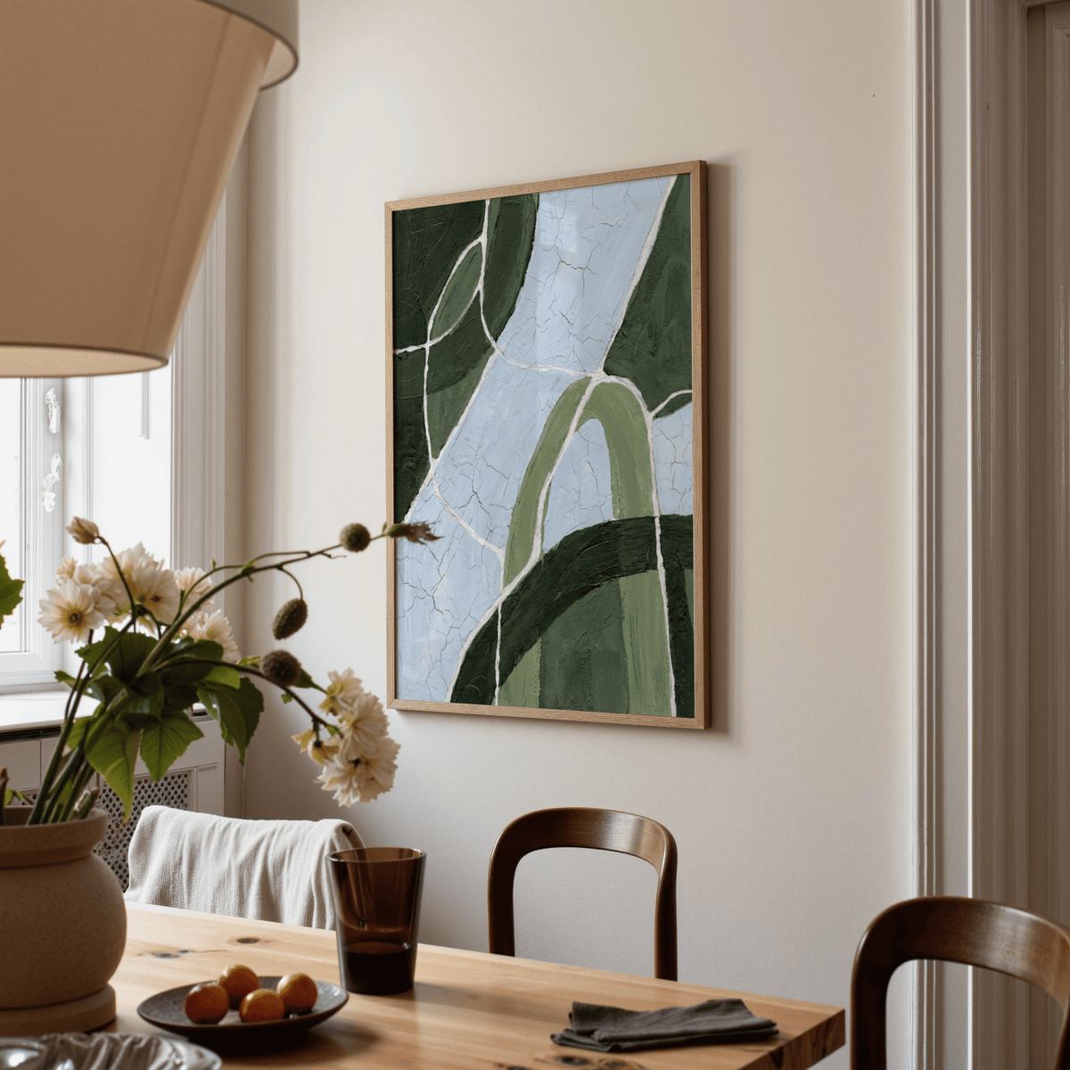 Green and blue art abstract stream wall art hanging above dining table with flowers