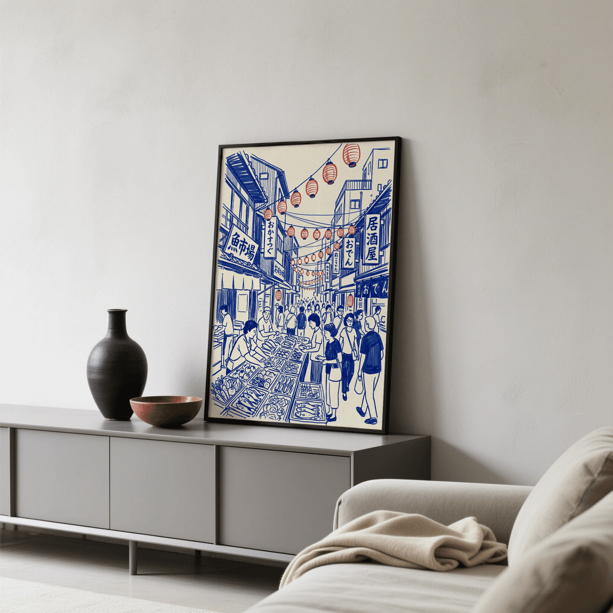Print leaning on a sideboard of a busy Japanese street market illustration with blue and red line-art in a living room