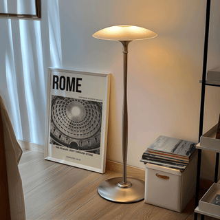 Pantheon Interior Poster print leaning on a wooden floor beside a floor lamp and stack of books