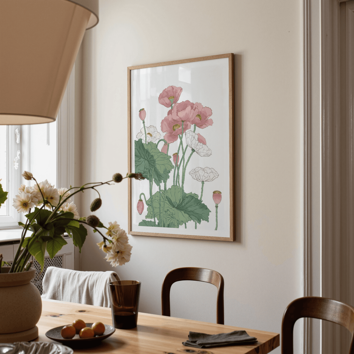 Botanical flower print of pink and white poppy blooms in a wooden frame above a dining table
