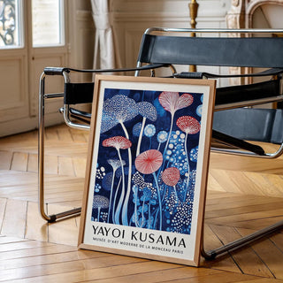 Mushroom art print with abstract blue and red mushrooms leaning on modern chair in light room