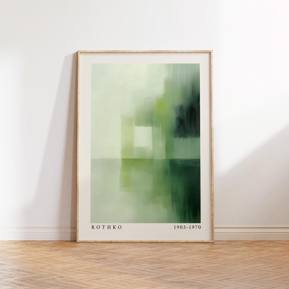 Print leaning on a wooden floor of olive green wall art with abstract shapes and text below