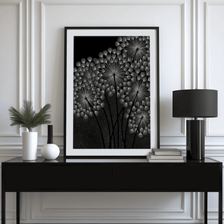 Dandelions wall art in black frame with white dandelion seed heads on black above a black sideboard