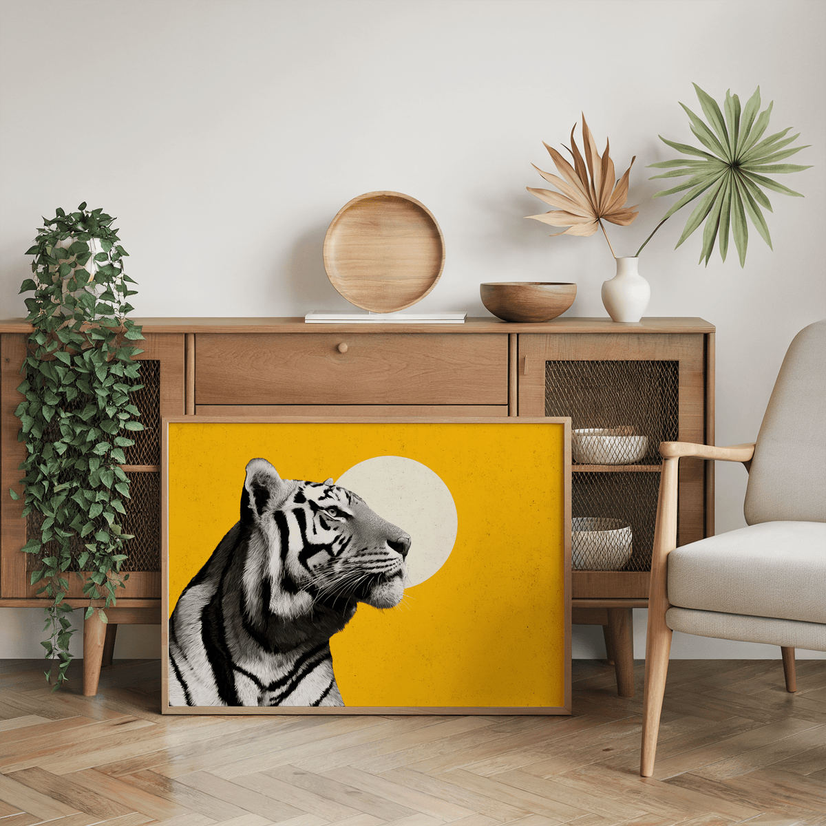 Print leaning on a wooden sideboard with a green plant and chair landscape tiger wall art with a yellow background and tiger head profile