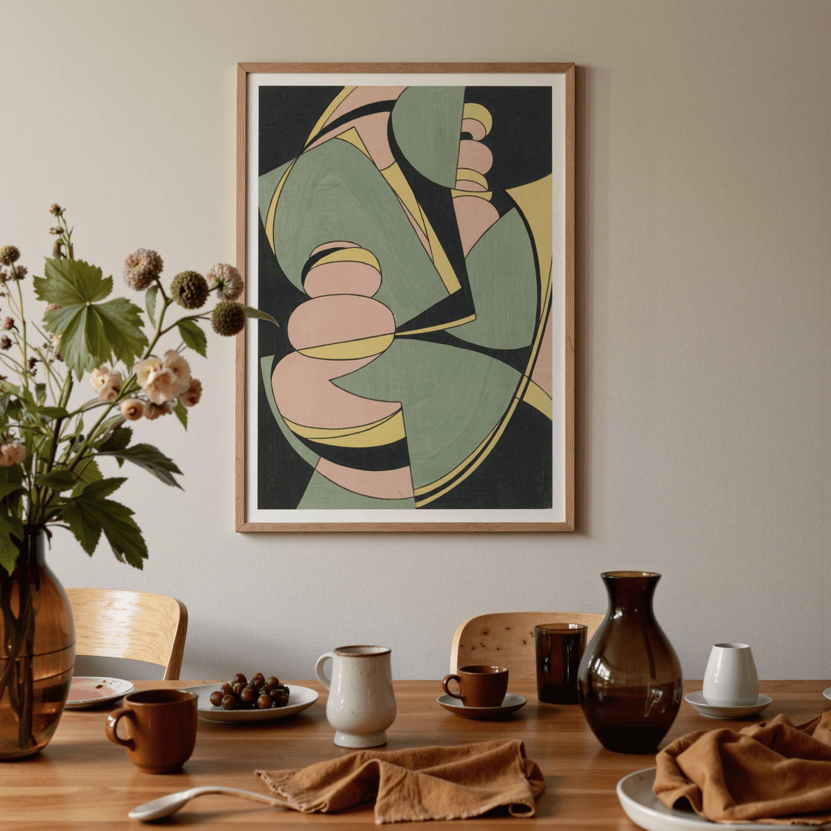 Abstract Geometric Art Print with pink green and yellow shapes above a wooden dining table with cups and a vase