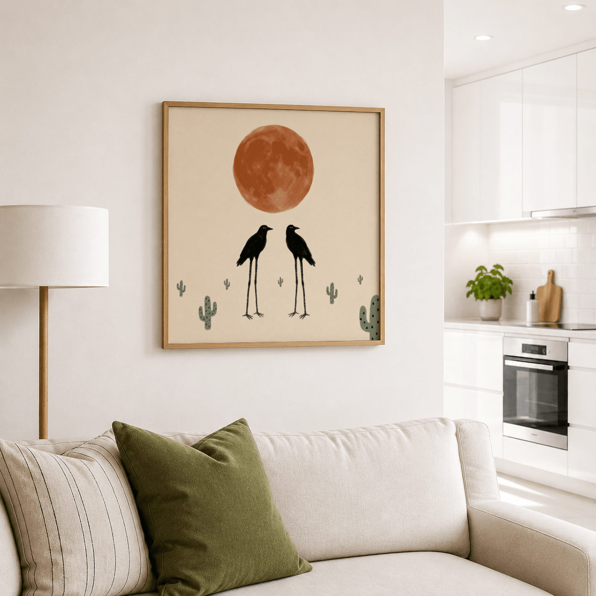 Cactus Bird wall art featuring two black birds and a large rust-coloured moon above a sofa with cushions